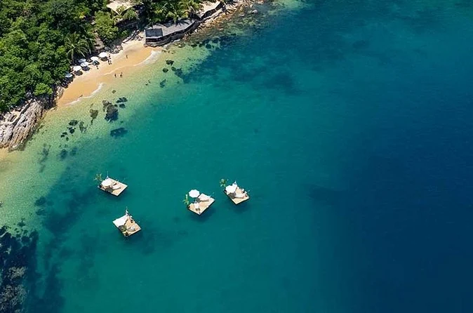 Aerial view of a jungle-backed cove with floating platforms